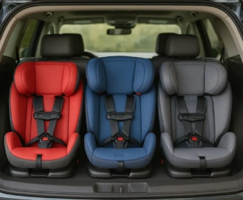 Three car seats fitted side by side in one row of an SUV